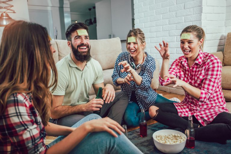 Heureux amis jouant au jeu devinez qui et s'amusant à la maison