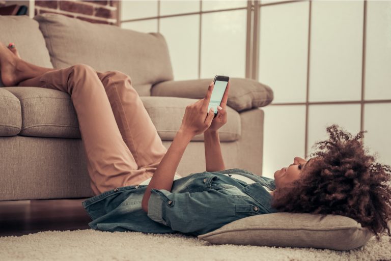 femme allongée sur le sol et bouton sur le téléphone