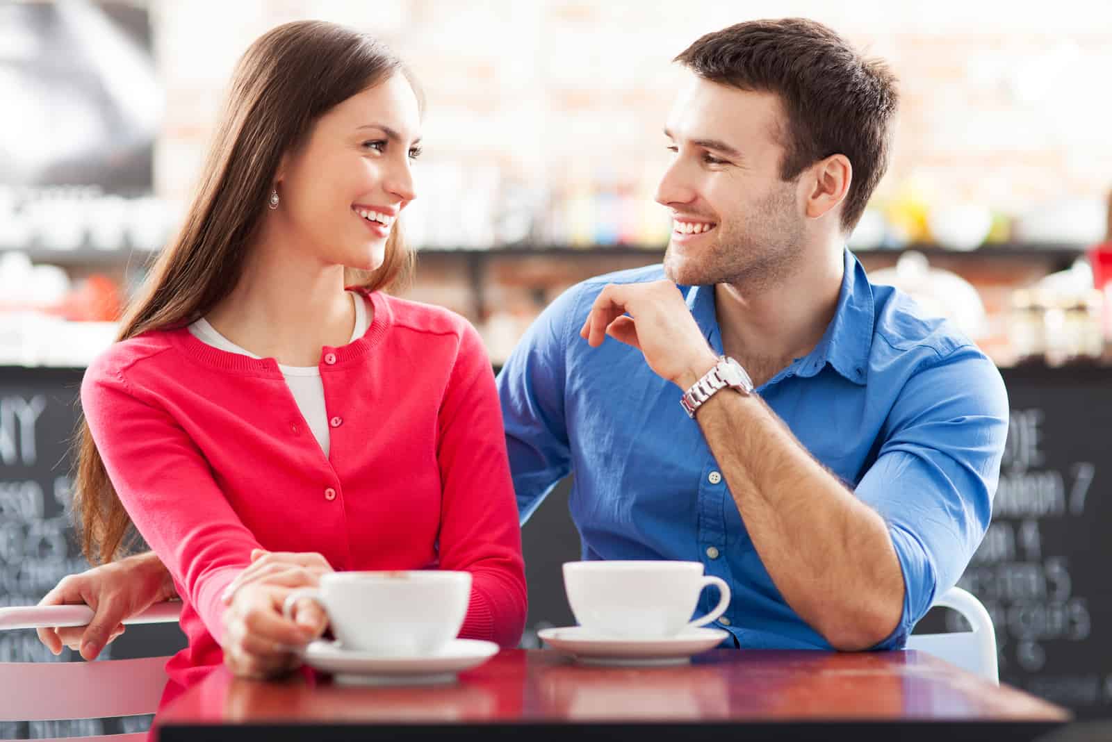 couple amoureux assis buvant du café et souriant