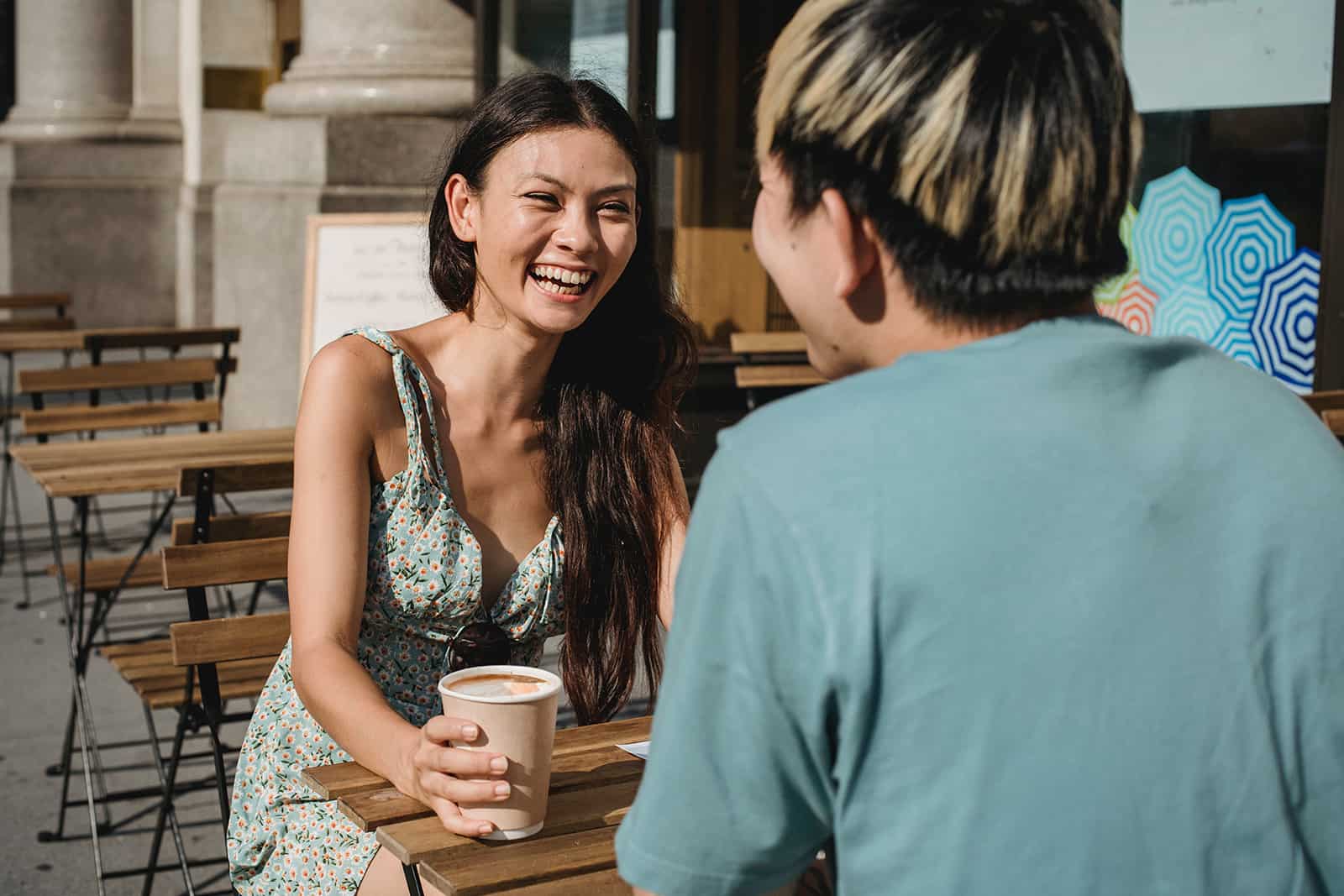 femme joyeuse assise avec un homme sur un café en plein air à une date
