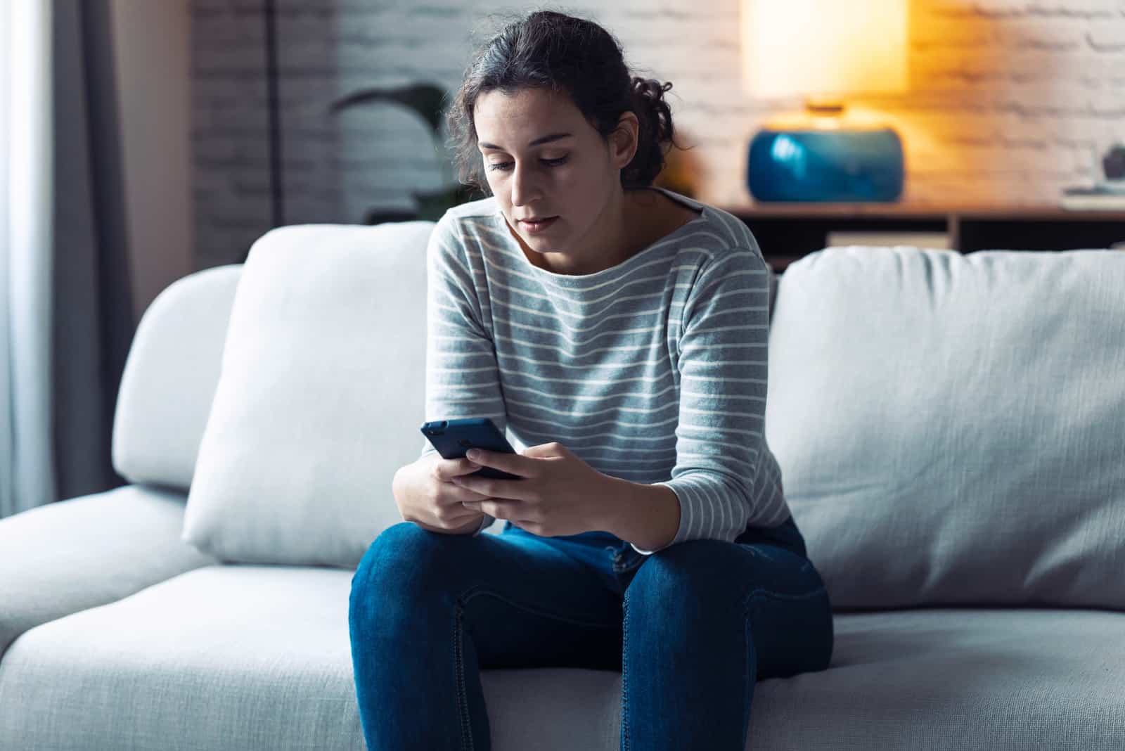 jeune femme sérieuse à l'aide de son téléphone portable