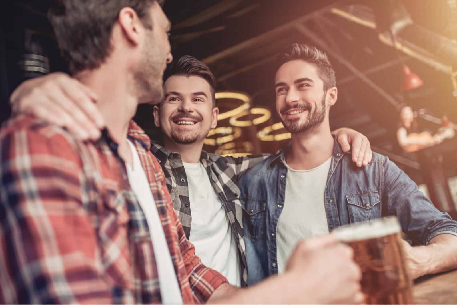 un homme avec des amis dans un café buvant de la bière et riant