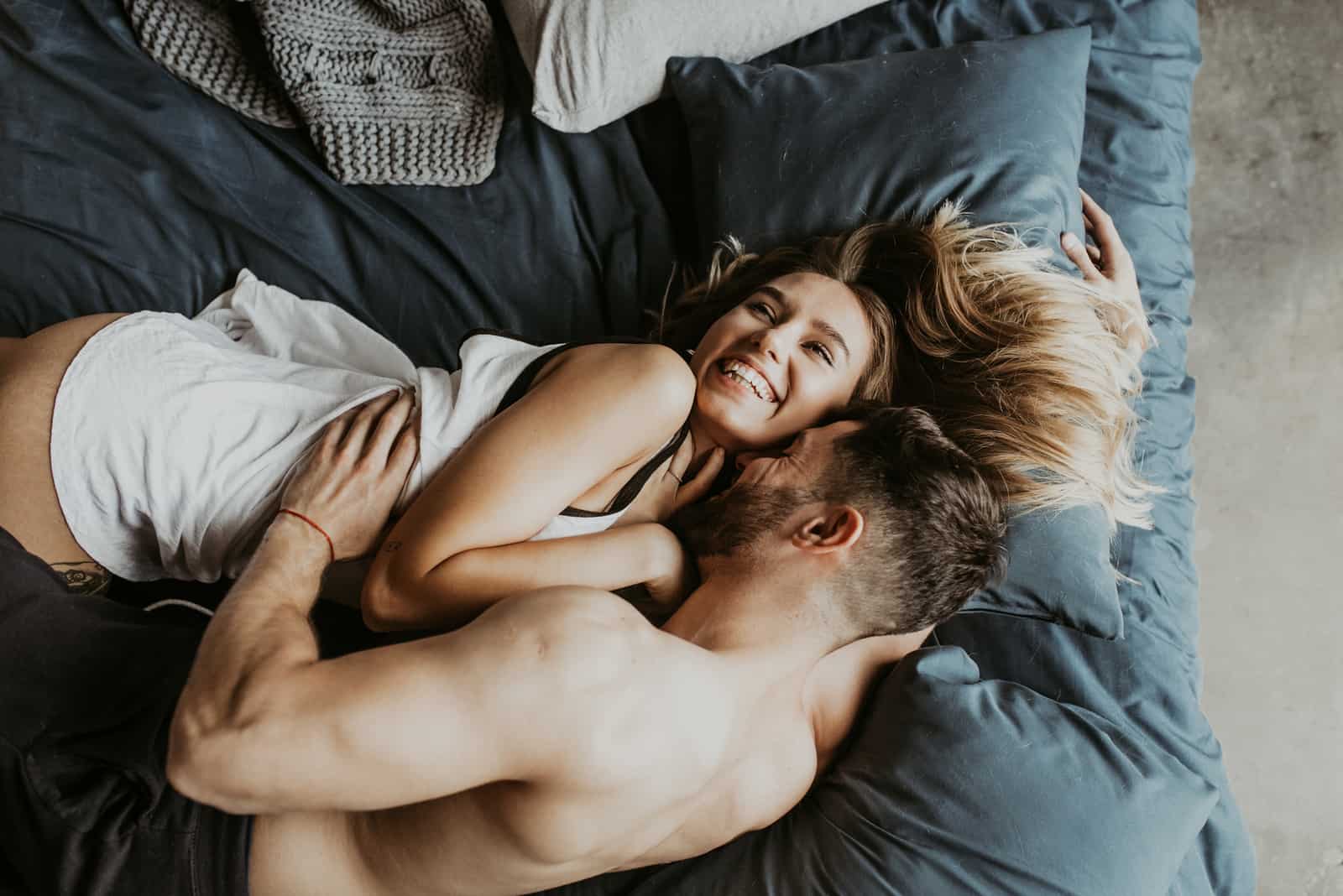 un homme et une femme étreignant dans son lit