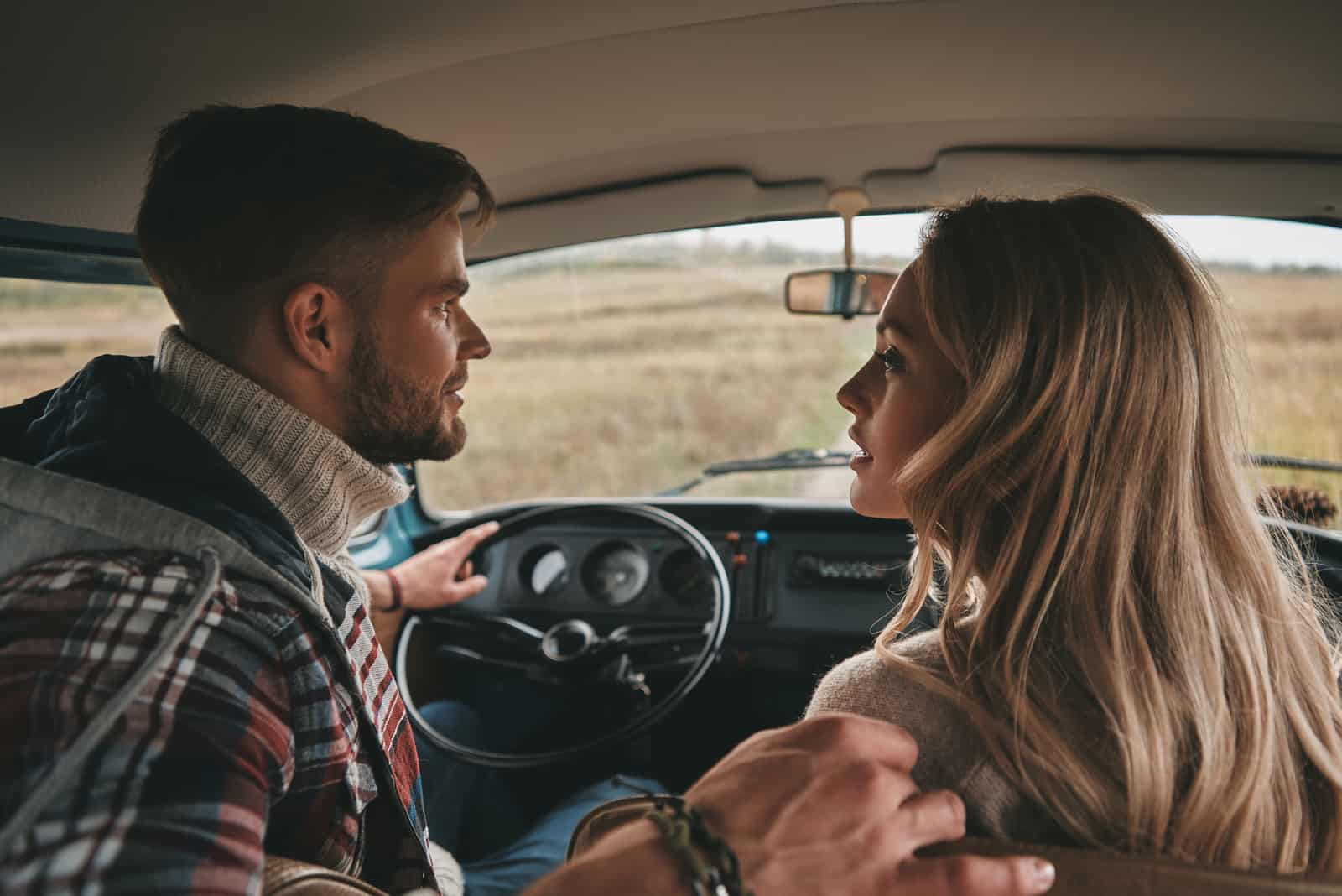 un homme et une femme parlent dans la voiture