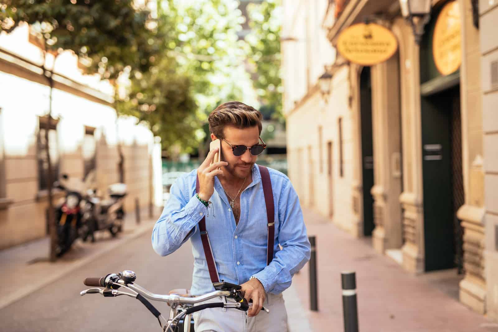 un homme fait du vélo à côté de lui et parle au téléphone