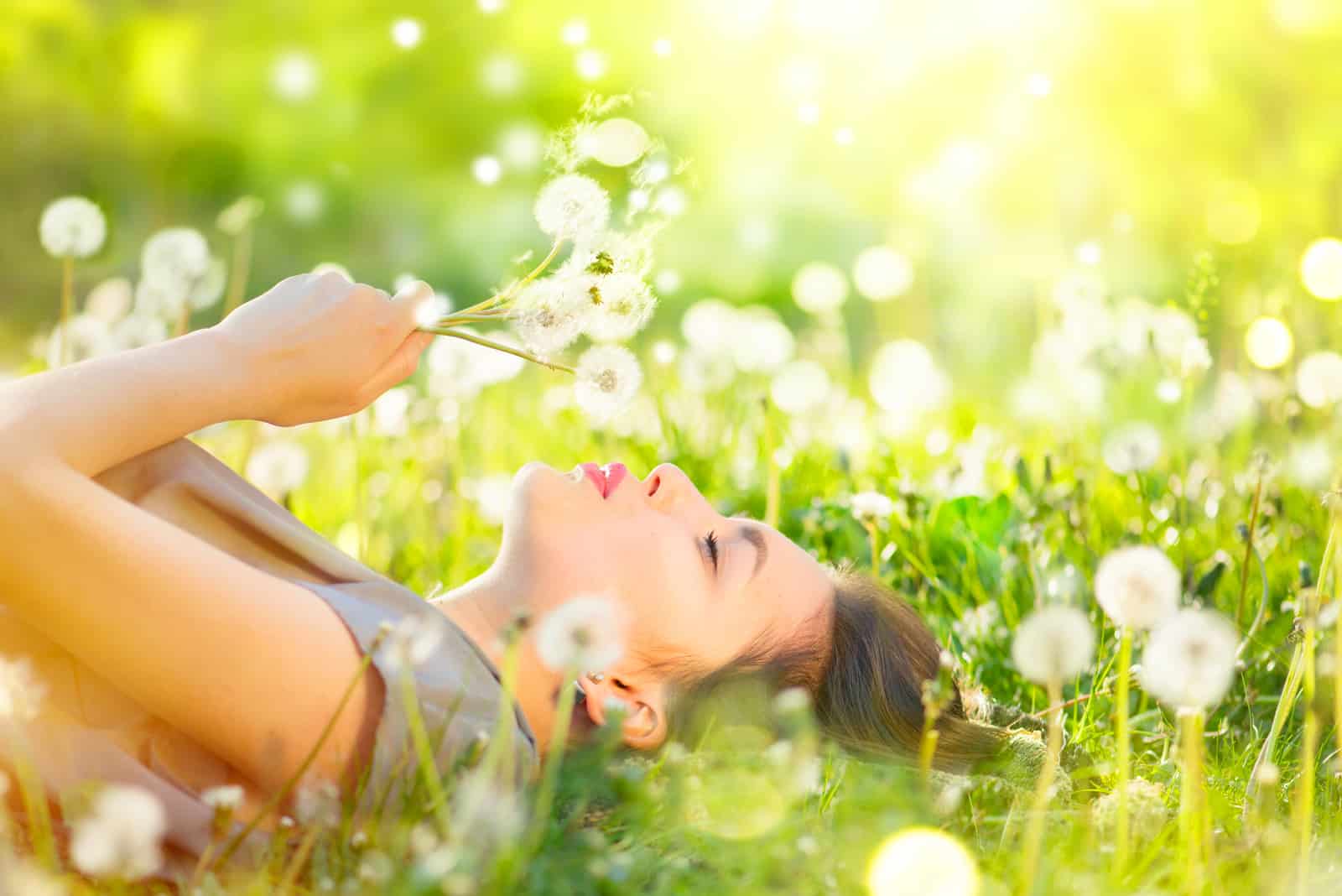 une femme souriante couchée dans l'herbe