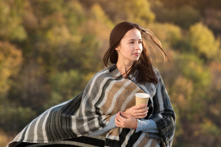 Jolie jeune femme enveloppée dans une couverture