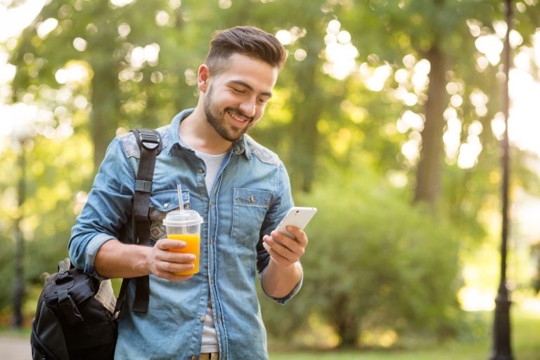 homme hipster marchant dans le parc automne et souriant