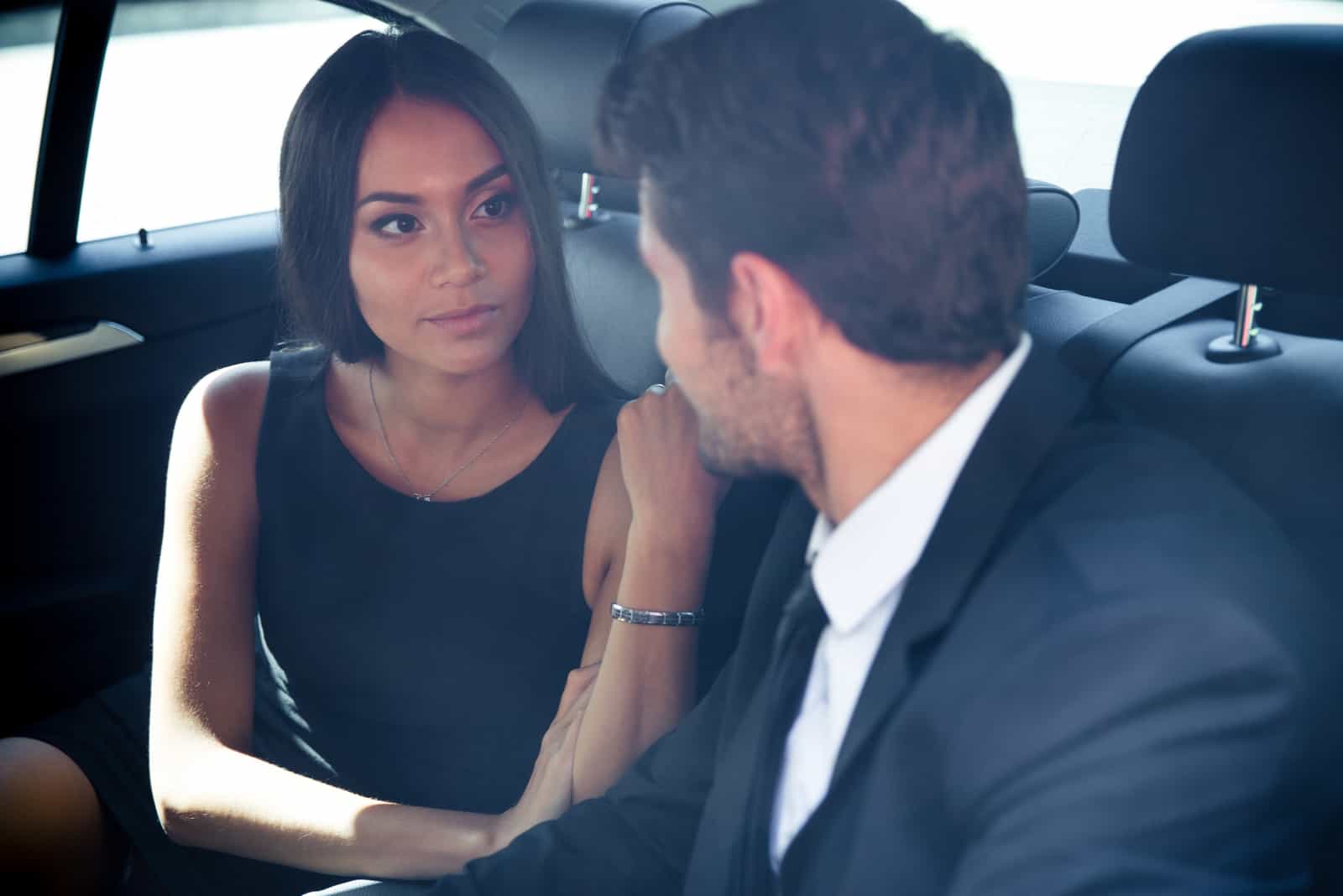 Homme affaires et femme affaires conversation dans siège arrière de voiture