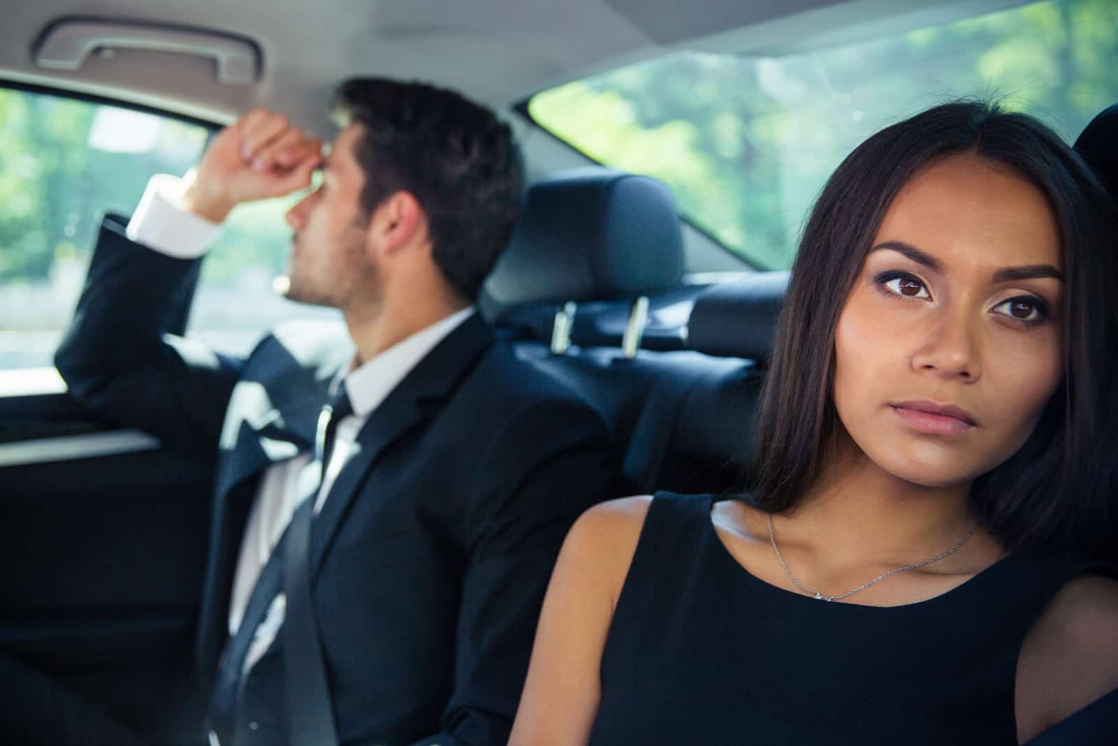 Homme affaires et femme affaires équitation sur siège arrière dans voiture