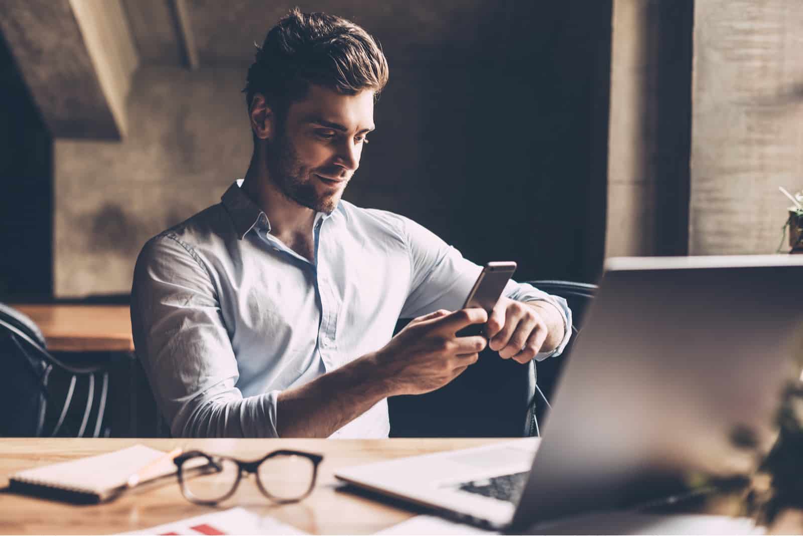Homme confiant en tenue décontractée tenant un téléphone intelligent