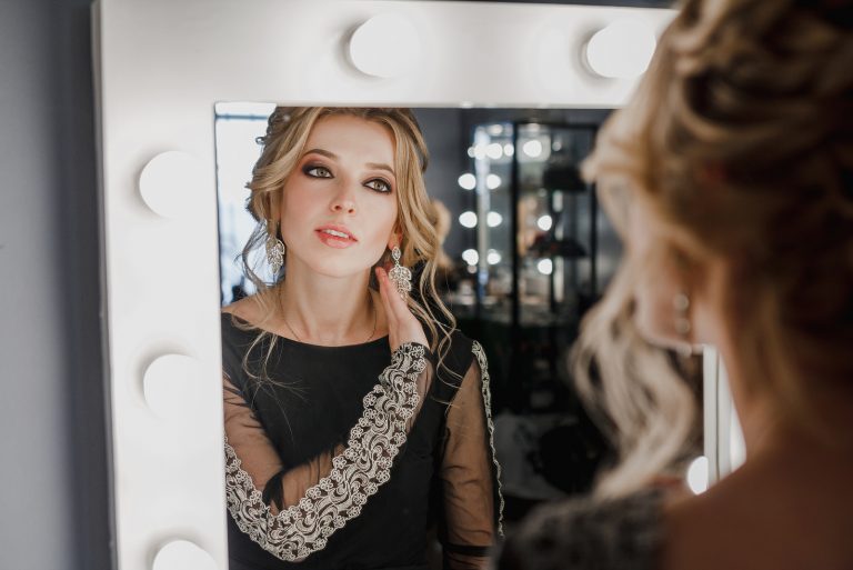 belle femme en robe noire regardant miroir