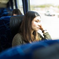 Femme regardant par la fenêtre lors d'un voyage en bus