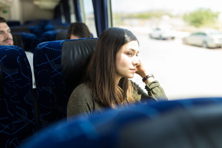 Femme regardant par la fenêtre lors d'un voyage en bus