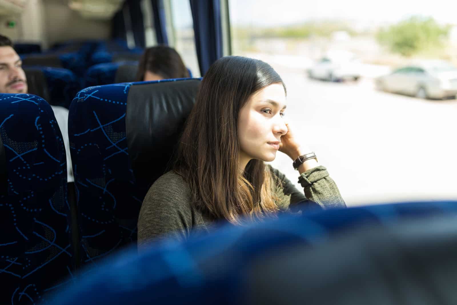 Femme regardant par la fenêtre lors d'un voyage en bus