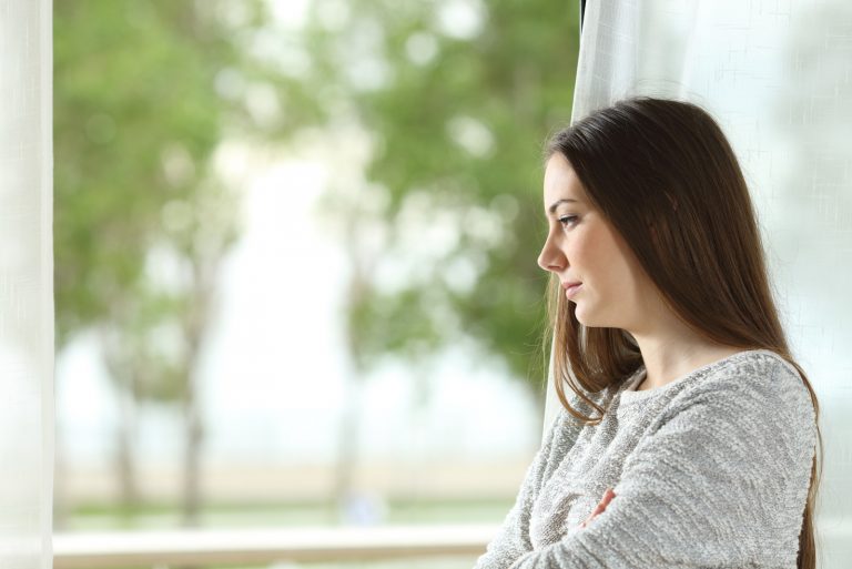femme regarder dehors par a fenêtre