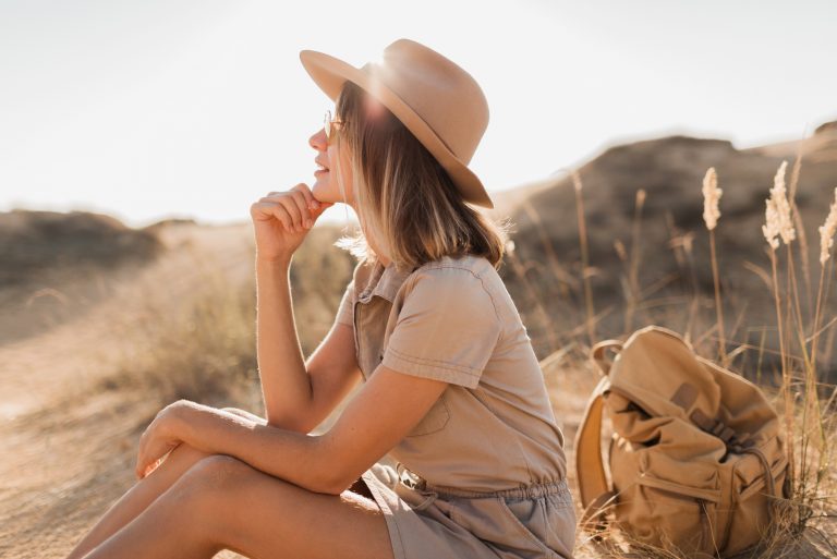 une belle femme avec un chapeau sur la tête est assise