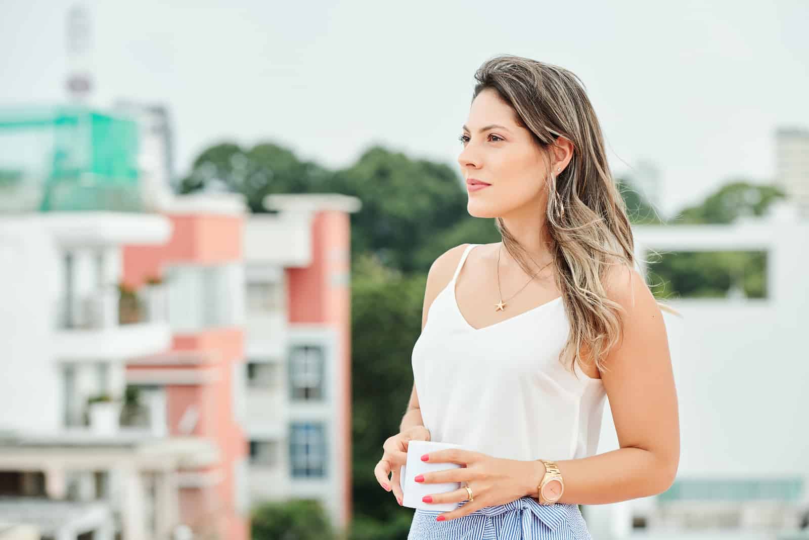 belle femme debout à l'extérieur et en détournant les yeux
