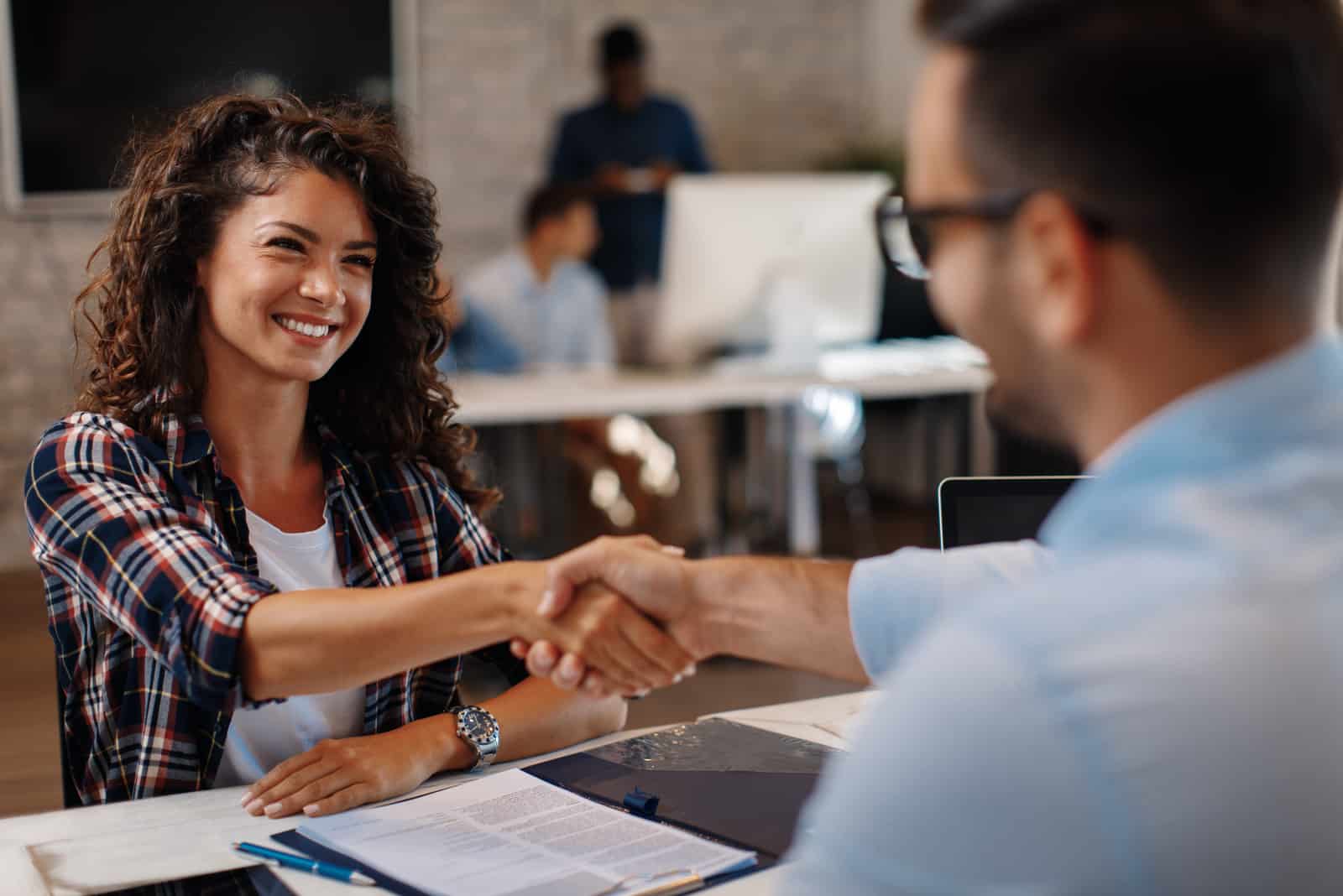 femme signant des contrats et poignée de main avec un gestionnaire