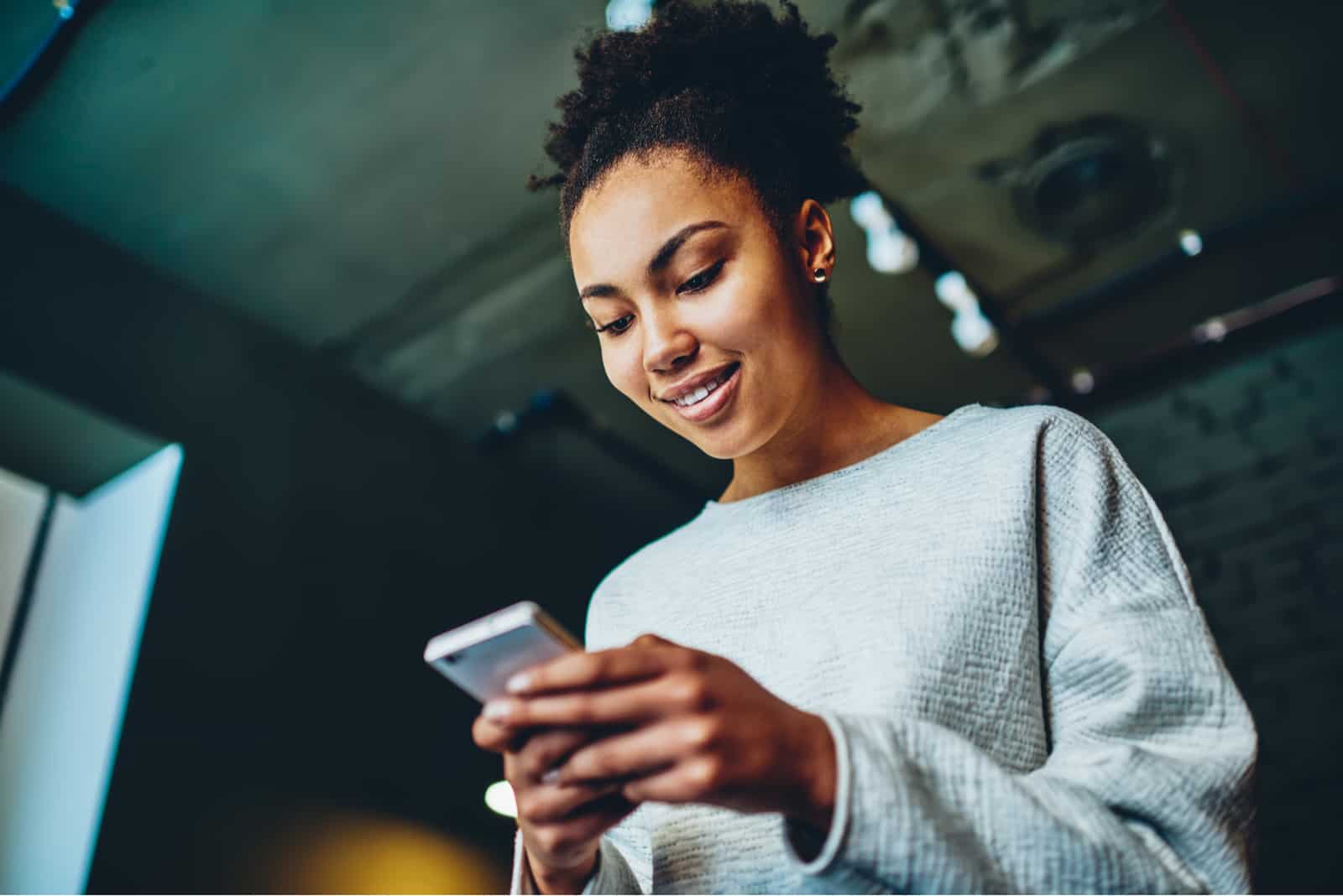 femme souriante tout en utilisant son téléphone