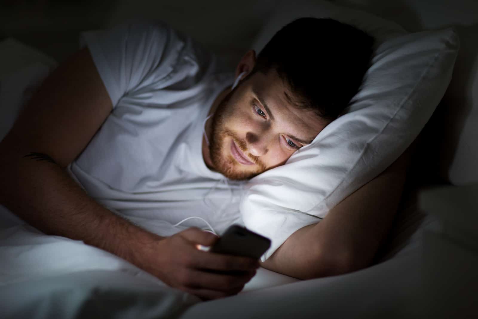 heureux sourire jeune homme à smartphone