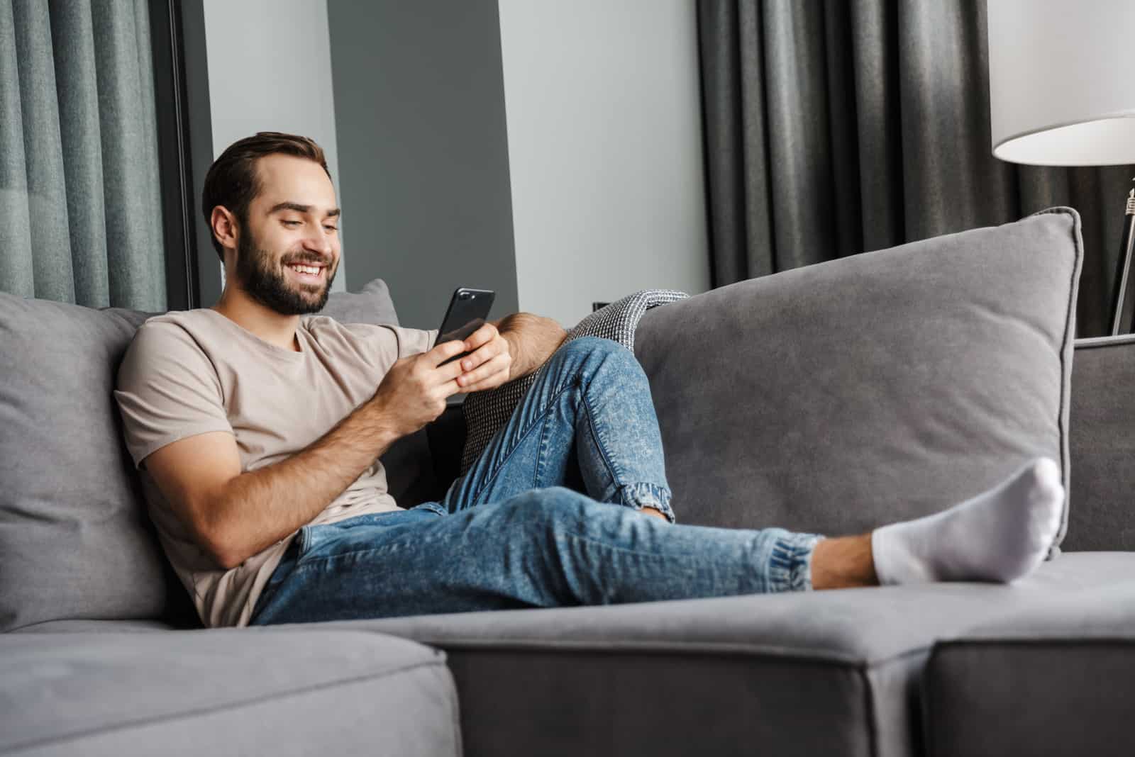 homme à la maison sur un canapé à l'aide de téléphone portable