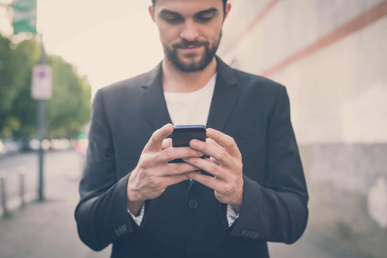 homme moderne hipster à aide de smartphone dans la ville