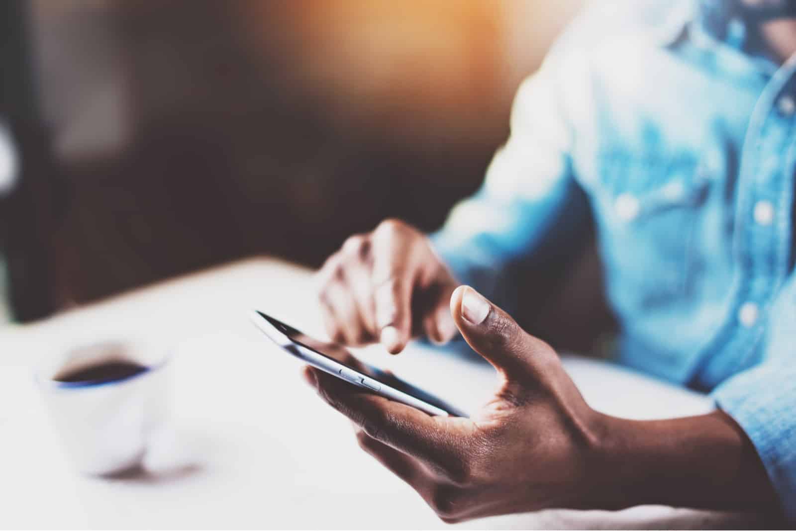 mains mâles touchant le téléphone mobile