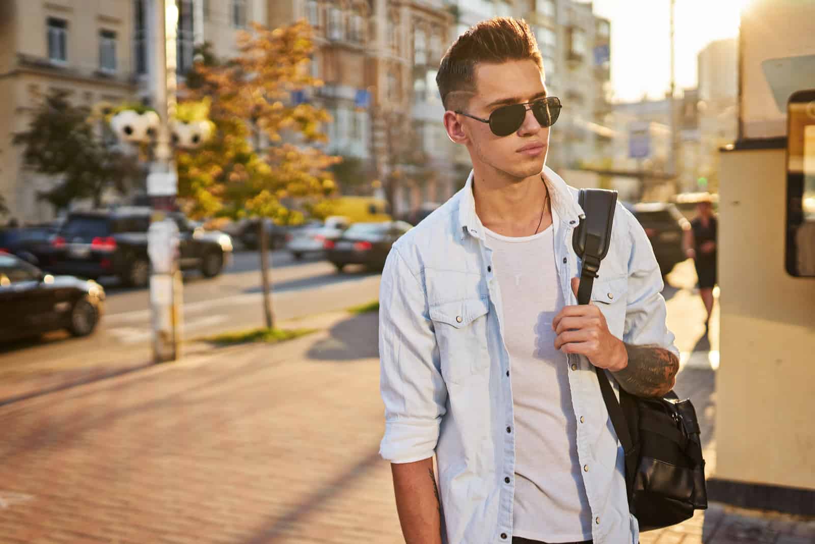 mec avec un sac à dos noir marchant