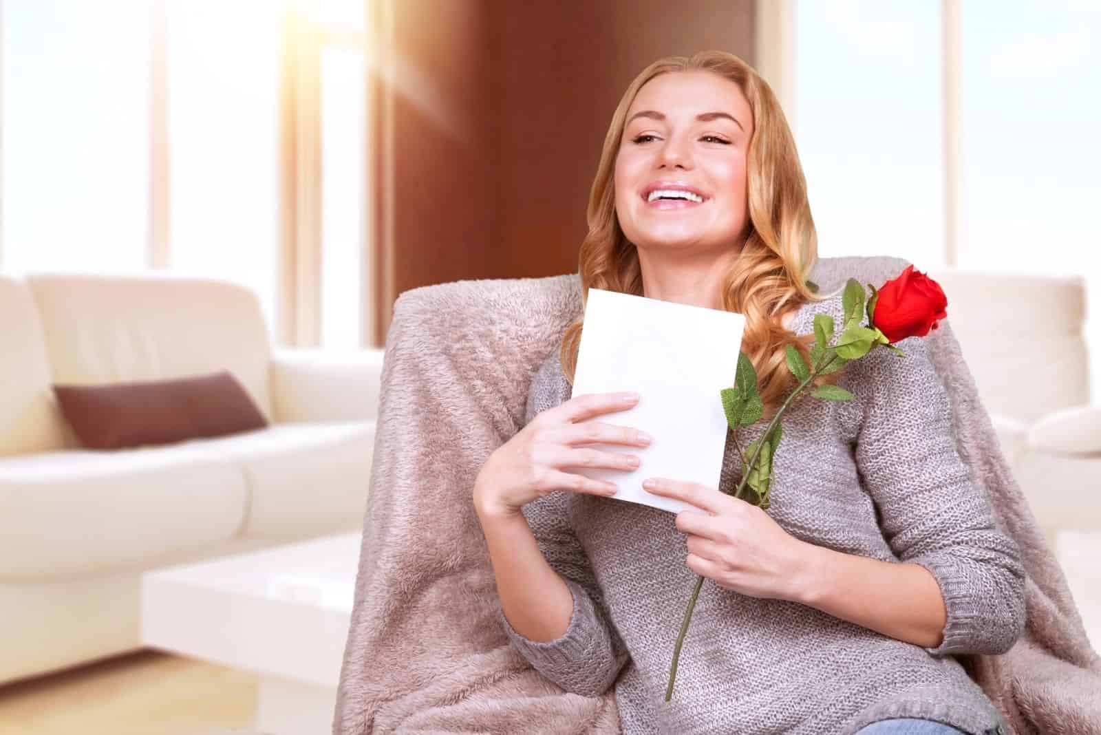 Femme heureuse appréciant carte de vœux, lire avec plaisir une lettre d'amour, recevoir une rose rouge, célébrer la Saint-Valentin à la maison