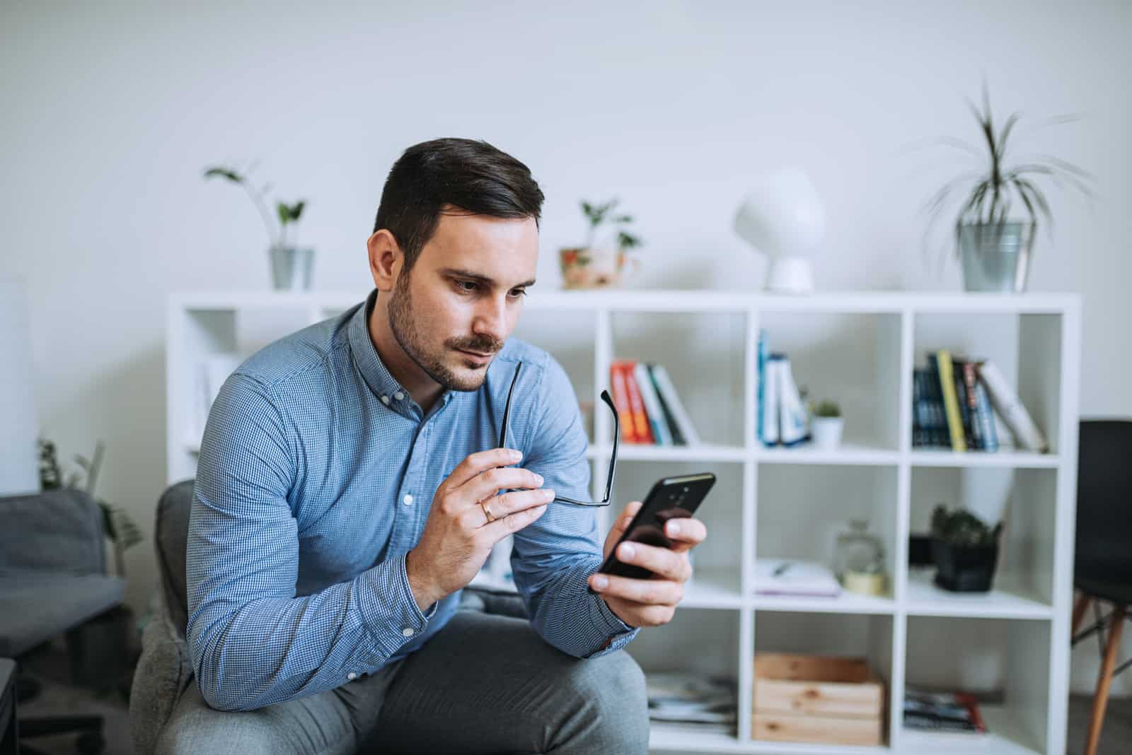 Homme d'affaires pensif à l'aide de son smartphone