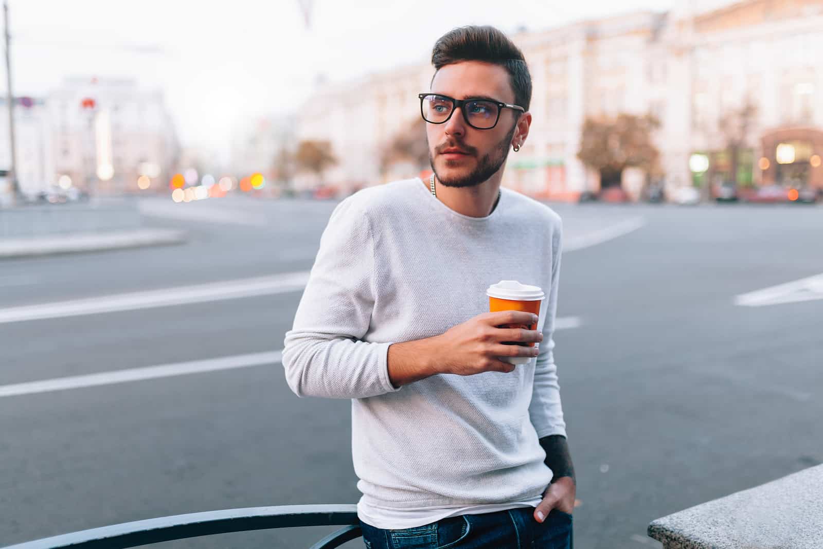 Homme de hipster debout avec du café à emporter