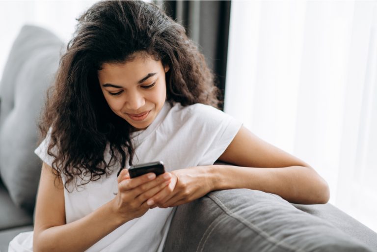 belle femme assise et touche au téléphone