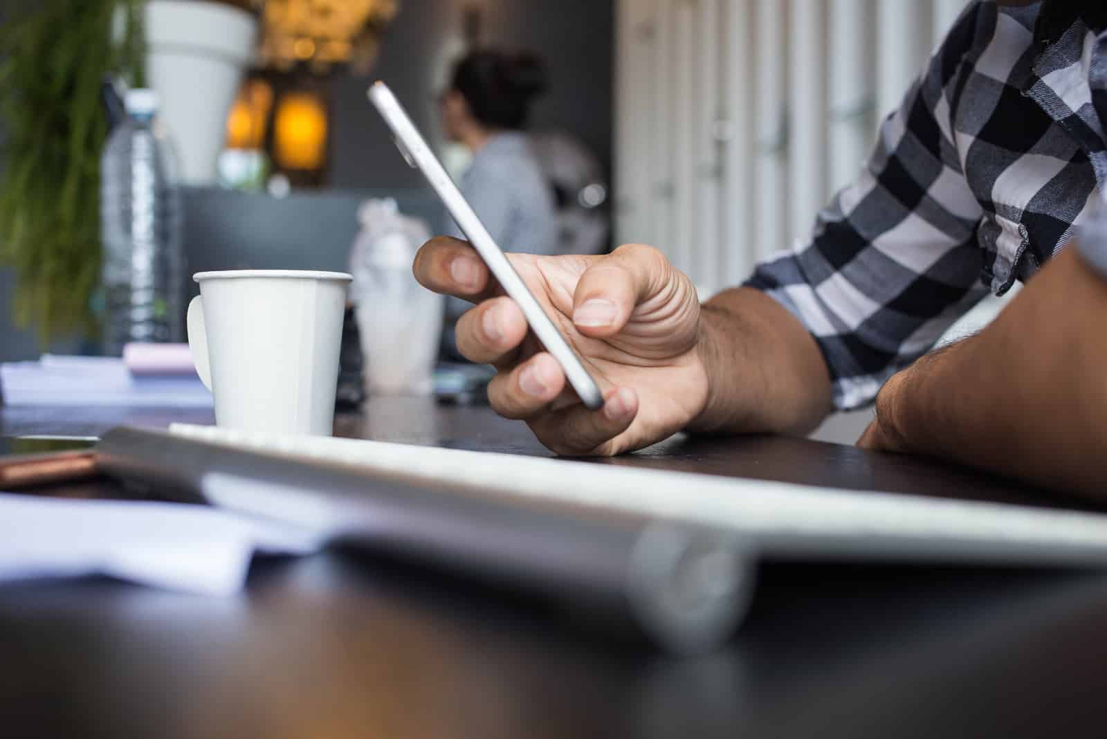 L'homme tenant un téléphone au bureau de table