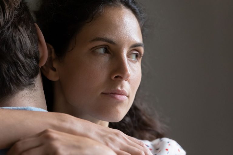 Close up pensif jeune femme étreignant l'homme, à la recherche à distance, en pensant aux problèmes de mariage, en doutant soupçonneux épouse embrassant son mari, en réfléchissant à la tricherie en relation,
