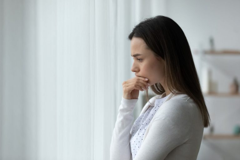 Frustré pensif jeune femme triste debout dans la salle de réflexion sur les problèmes, recherche de solution