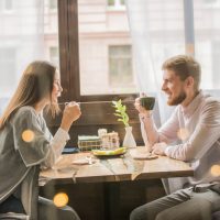 homme et femme prenant un café au café