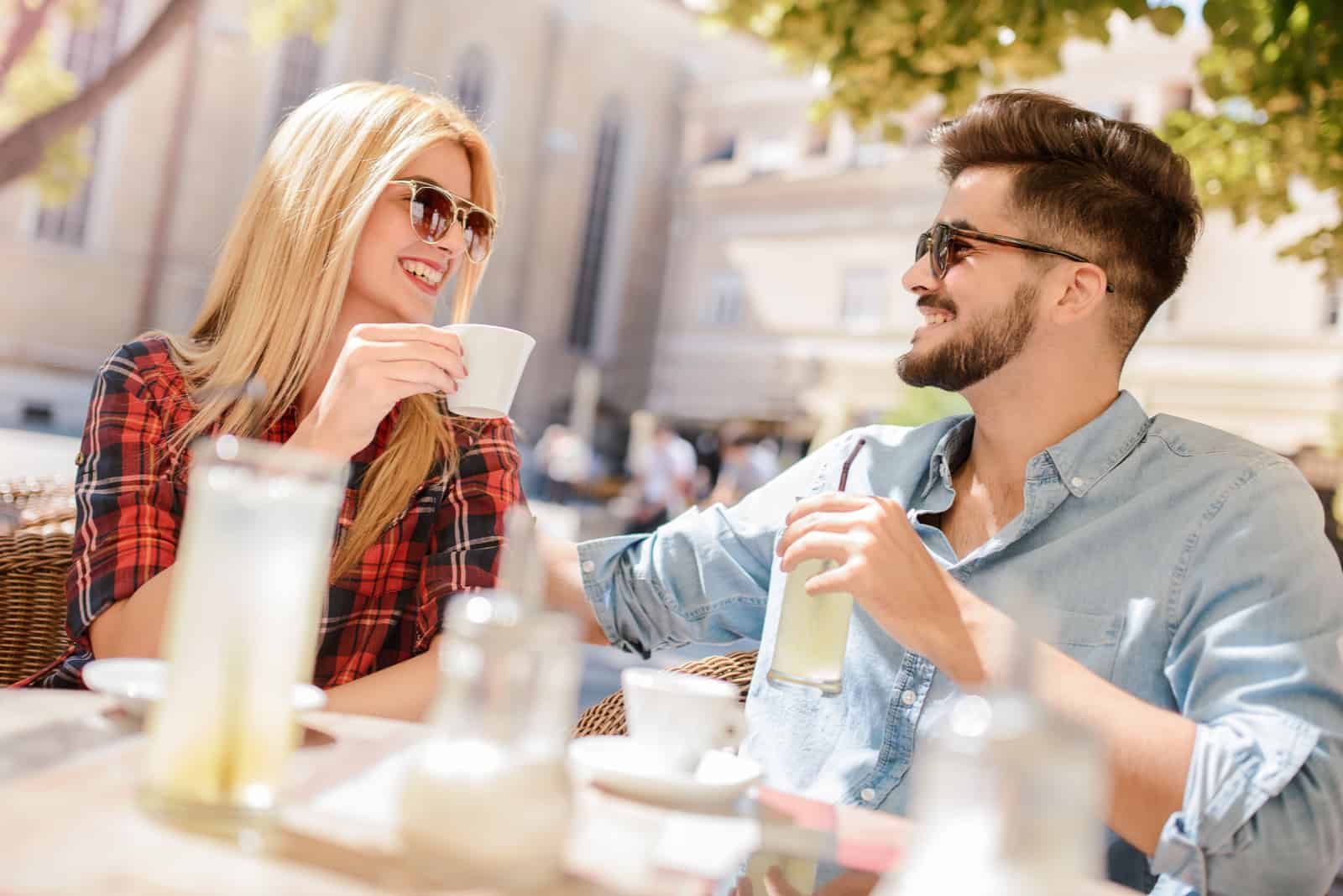 homme et femme prenant un café assis en plein air