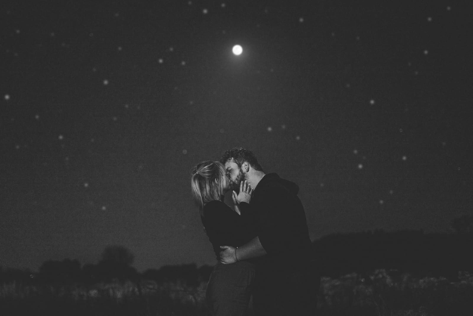 homme et femme s'embrassant en plein air dans la nuit