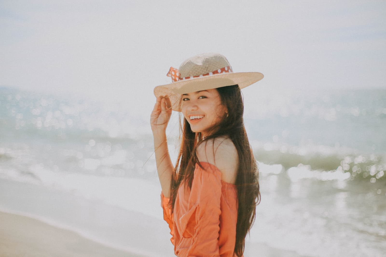 femme heureuse avec chapeau debout près de la mer