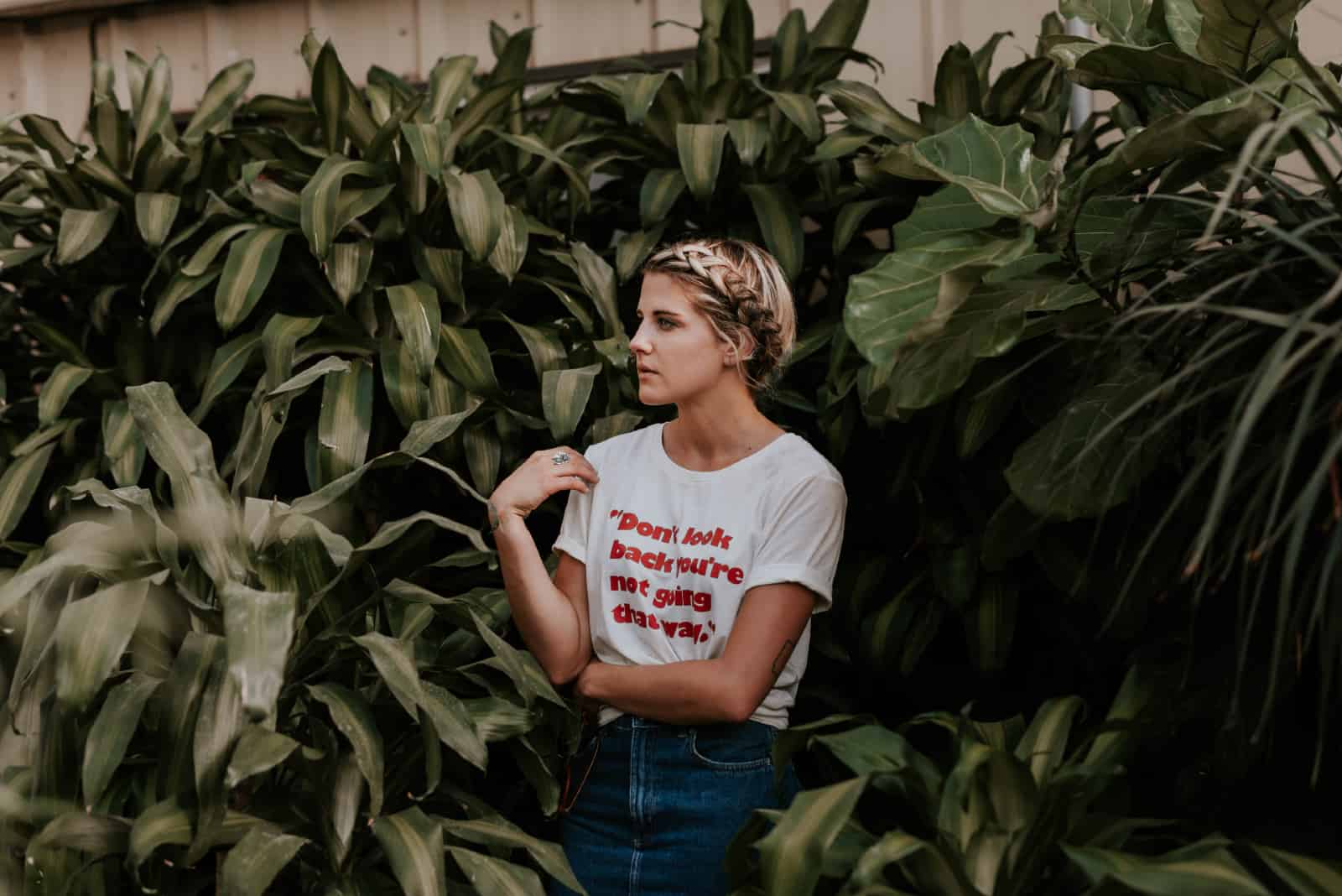 femme en t-shirt blanc debout près des plantes