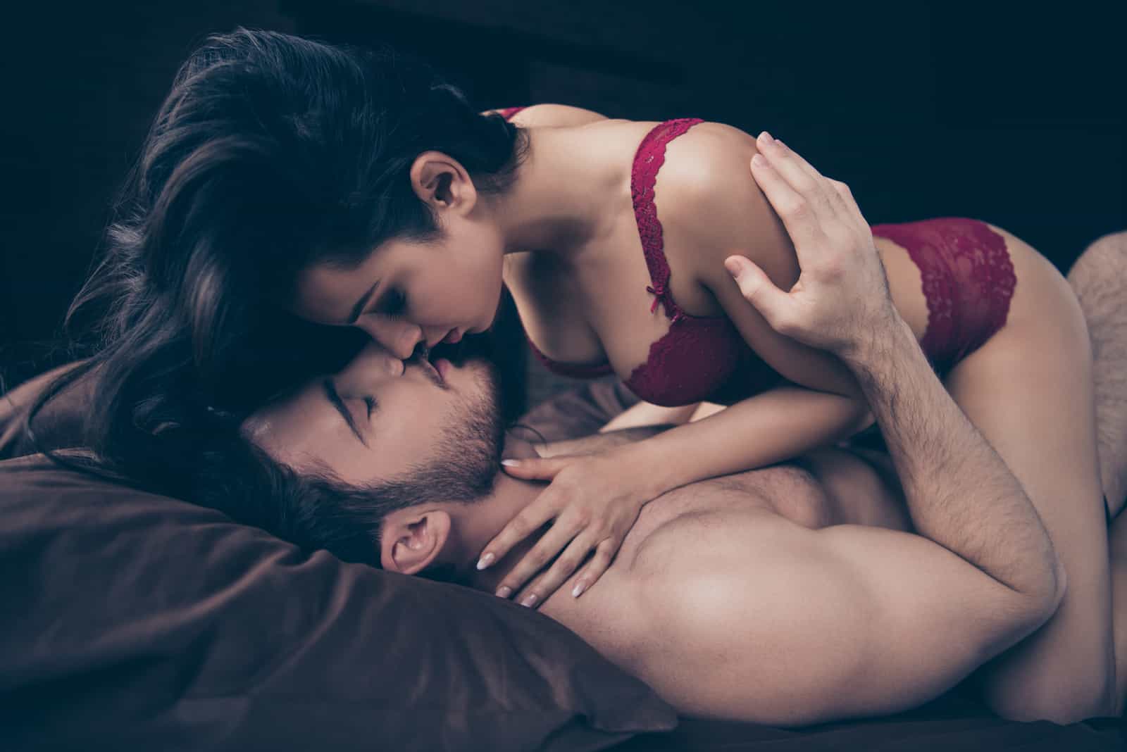 femme sur le point d'embrasser l'homme au lit