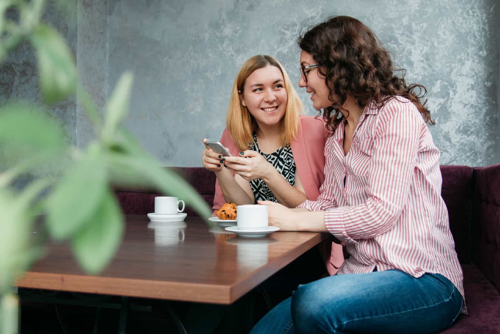 deux femmes qui parlent assis dans un café