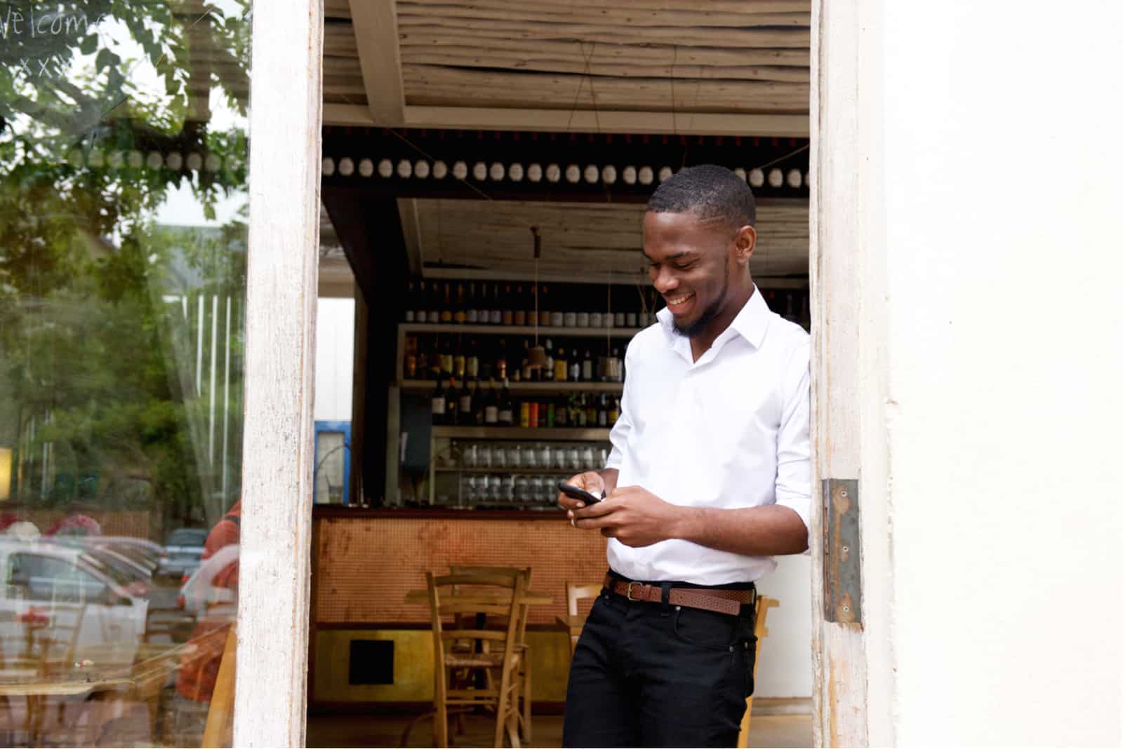 homme d affaires souriant en regardant un téléphone mobile