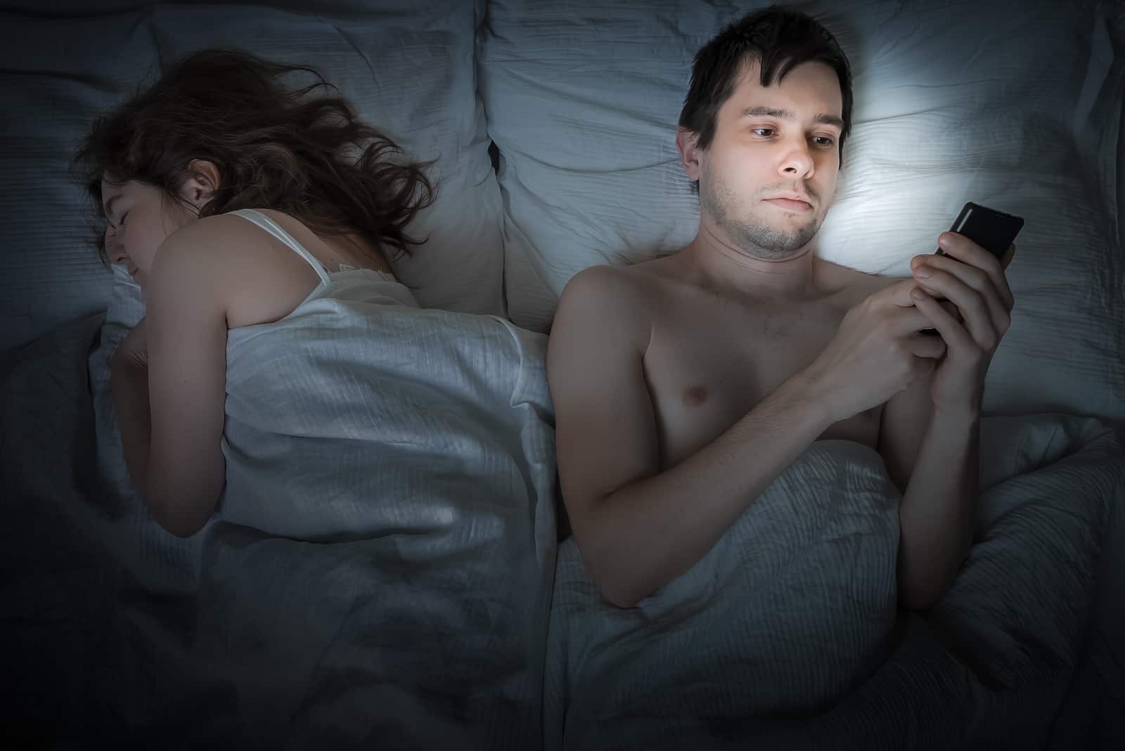 homme, utilisation, smartphone, pose, côté, femme, dans lit