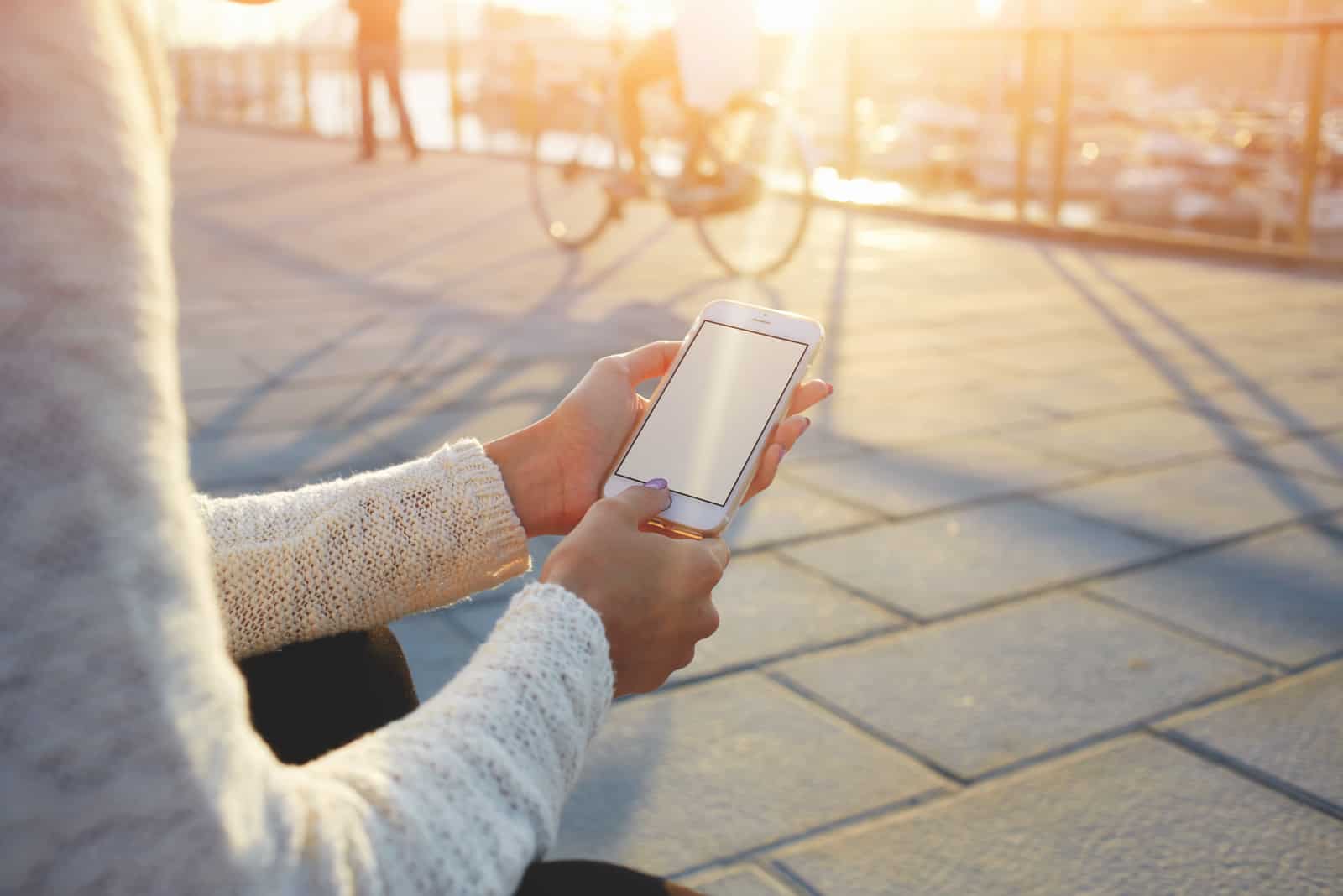mains de femme tenant un téléphone intelligent