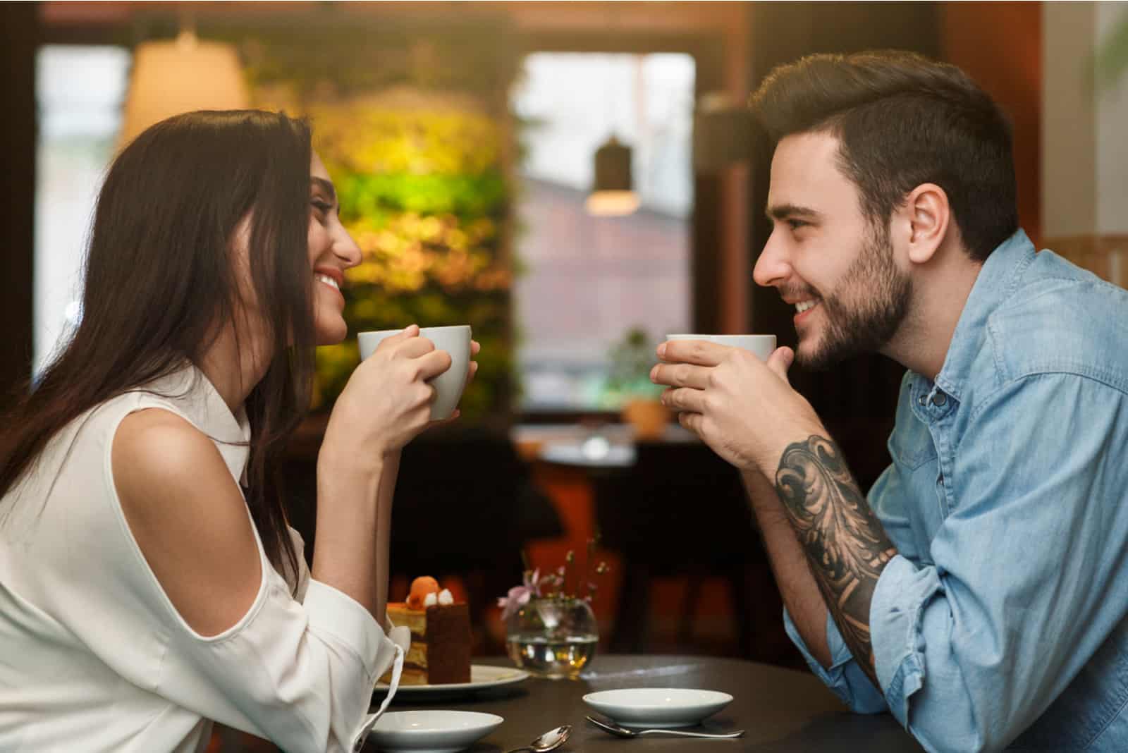 Amoureux appréciant des boissons au café ensemble pendant un rendez-vous romantique