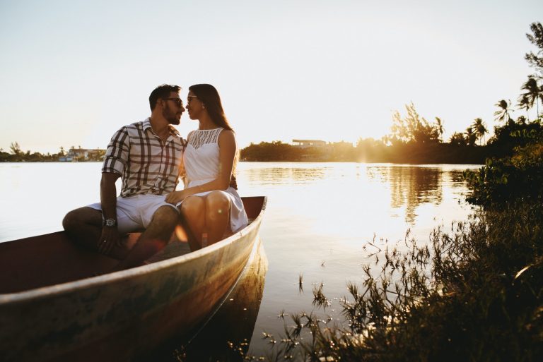 homme et femme sur le point de s'embrasser assis sur un bateau
