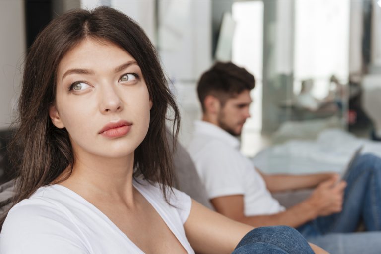 femme pensive assise sur un sofa près d'un homme