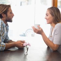homme et femme discutant assis dans un café